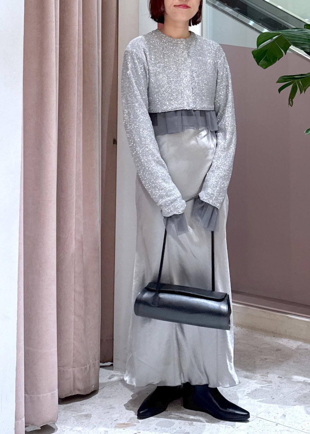 ブラック系のショルダーバッグ、ブラック系のブーツ、グレー系のカーディガン/ボレロを着用したレディースの冬コーディネートの2枚目の写真