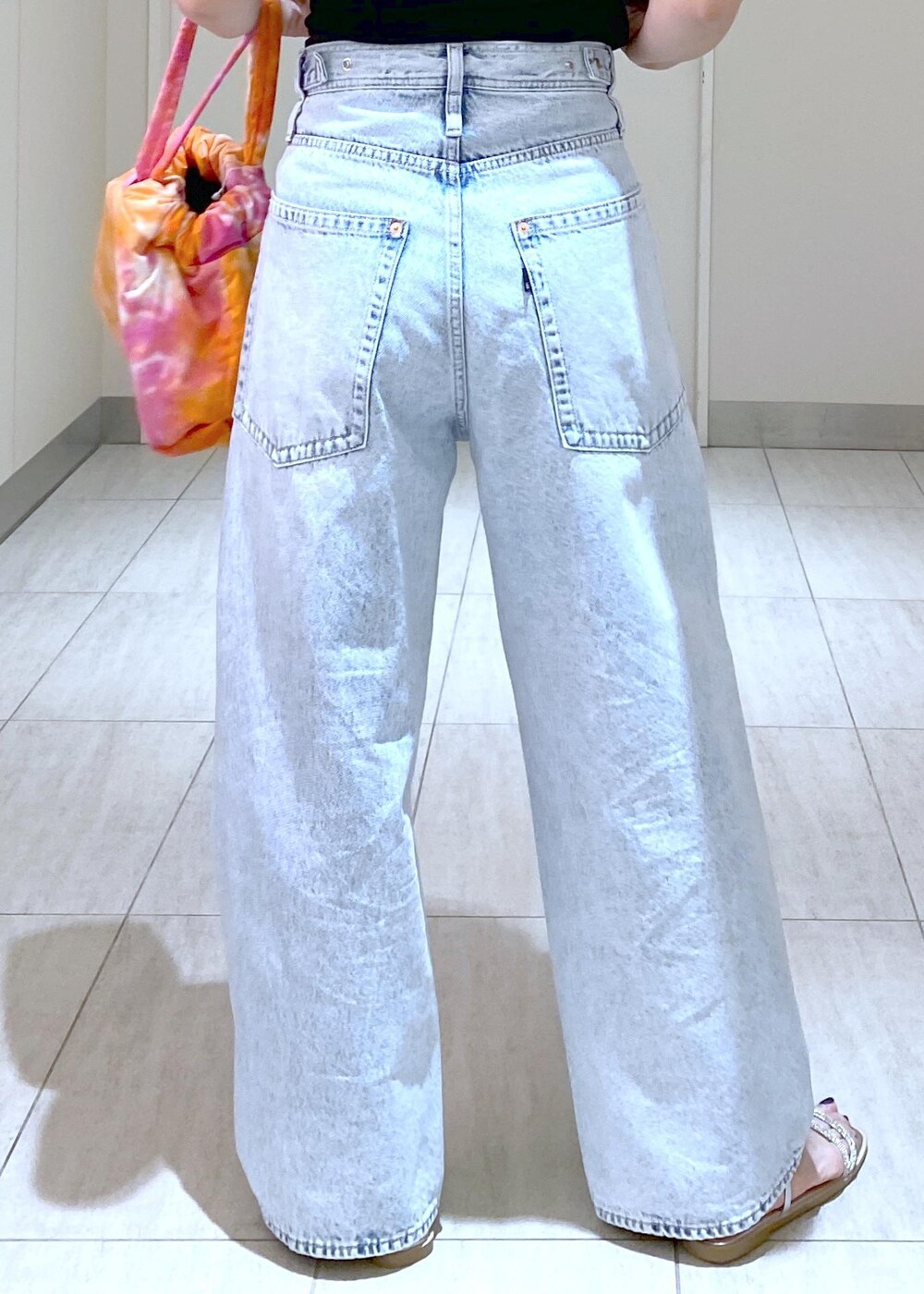 シルバー系のサンダル、ブラック系のニット/セーター、ブルー系のデニムパンツを着用したレディースの春コーディネートの10枚目の写真