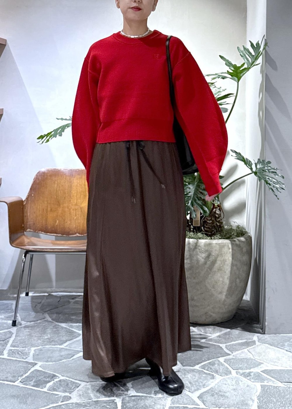 ブラック系のブーツ、ブラウン系のスカート、レッド系のニット/セーターを着用したレディースの秋コーディネートの7枚目の写真