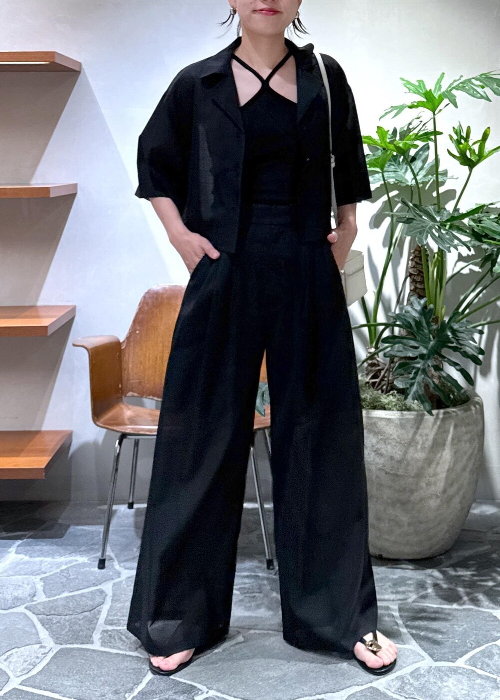 ホワイト系のショルダーバッグ、ブラック系のキャミソール、ブラック系のスラックスを着用したレディースの夏コーディネートの3枚目の写真