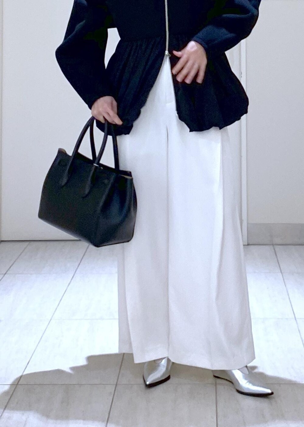 ホワイト系のその他パンツ、ブラック系のカーディガン/ボレロ、シルバー系のパンプスを着用したレディースの冬コーディネートの8枚目の写真