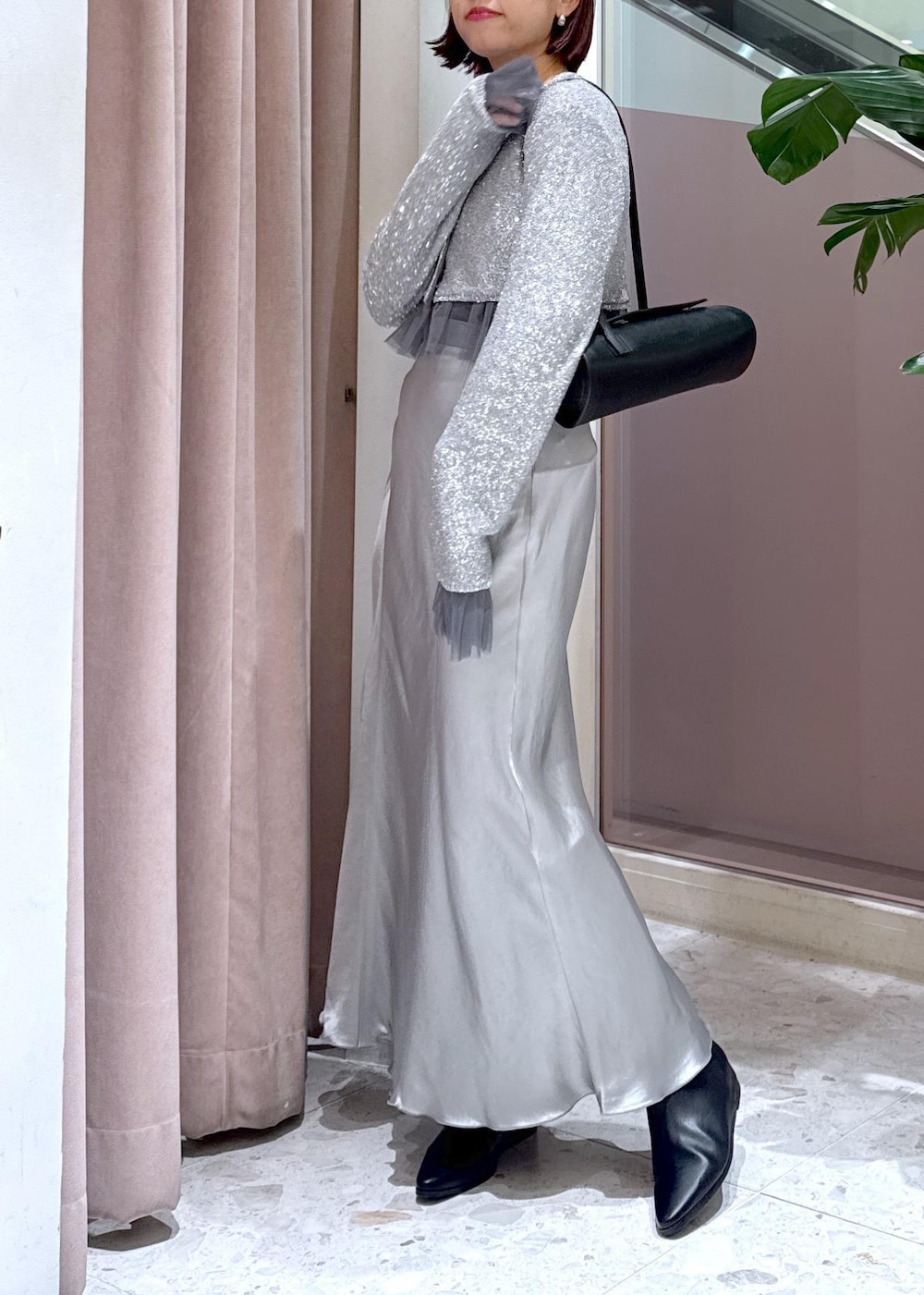 ブラック系のショルダーバッグ、ブラック系のブーツ、グレー系のカーディガン/ボレロを着用したレディースの冬コーディネートの4枚目の写真