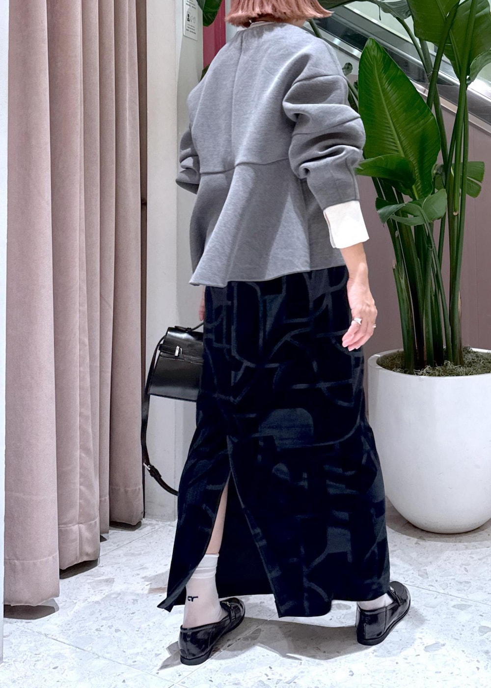 ブラック系のローファー、ブラック系のスカート、グレー系のカーディガン/ボレロを着用したレディースの秋コーディネートの6枚目の写真