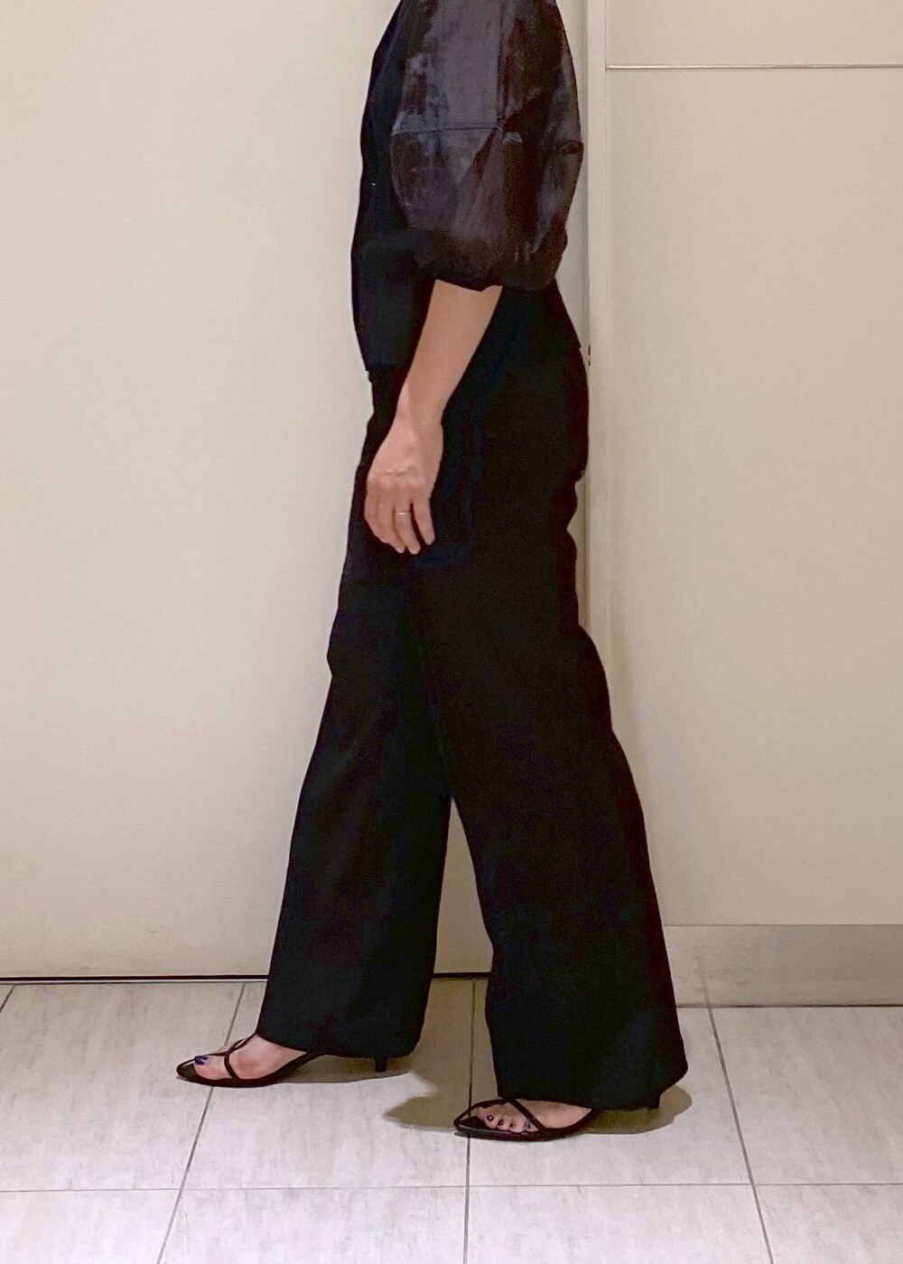 ブラック系のサンダル、ホワイト系のショルダーバッグ、ブラック系のスラックスを着用したレディースの夏コーディネートの7枚目の写真