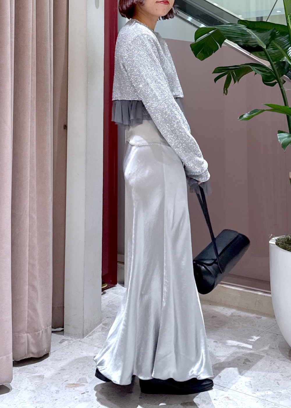 ブラック系のショルダーバッグ、ブラック系のブーツ、グレー系のカーディガン/ボレロを着用したレディースの冬コーディネートの5枚目の写真