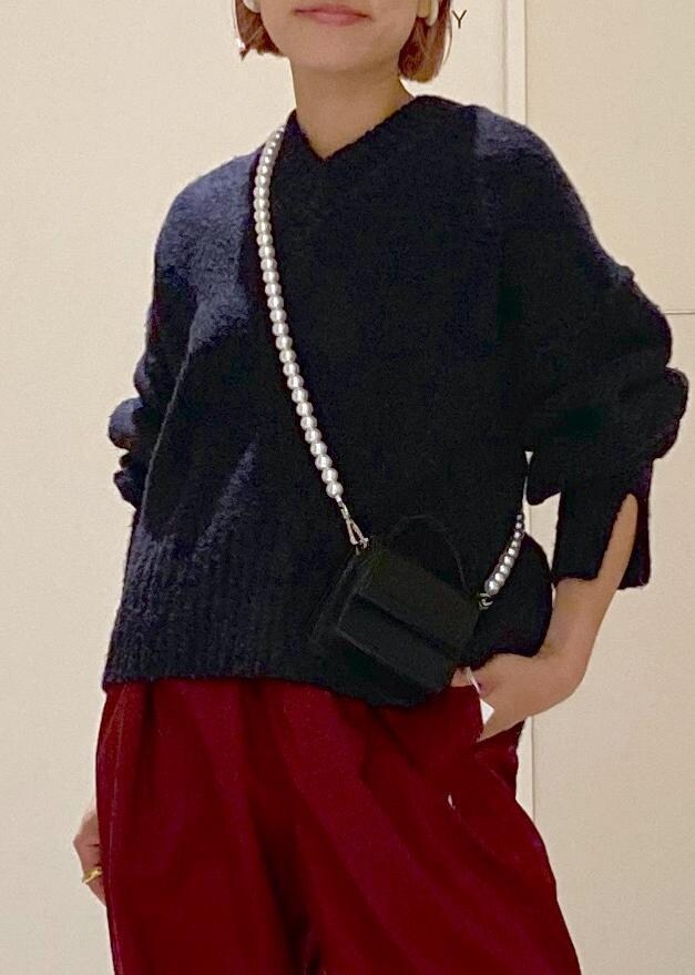 ブラック系のニット/セーター、ブラック系のショルダーバッグ、レッド系のその他パンツを着用したレディースの秋コーディネートの5枚目の写真