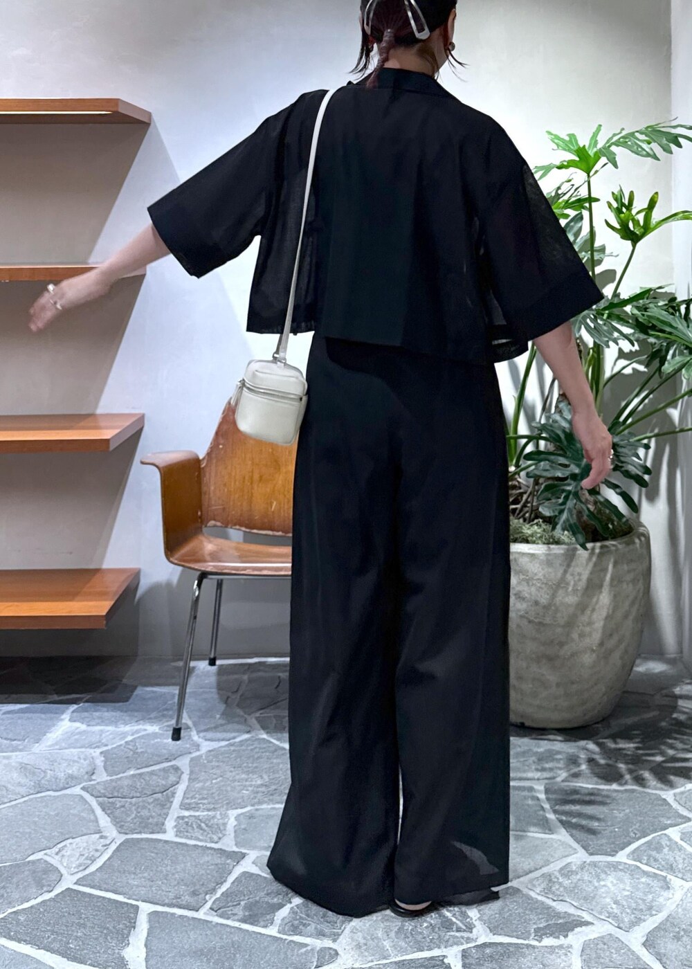 ホワイト系のショルダーバッグ、ブラック系のキャミソール、ブラック系のスラックスを着用したレディースの夏コーディネートの6枚目の写真