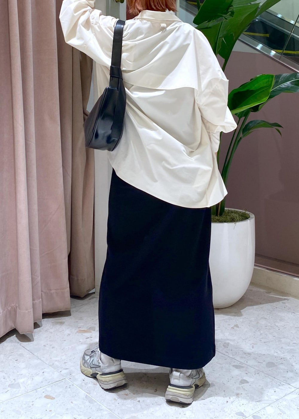 ブラック系のショルダーバッグ、ブラック系のワンピース、ホワイト系のシャツ/ブラウスを着用したレディースの春コーディネートの6枚目の写真