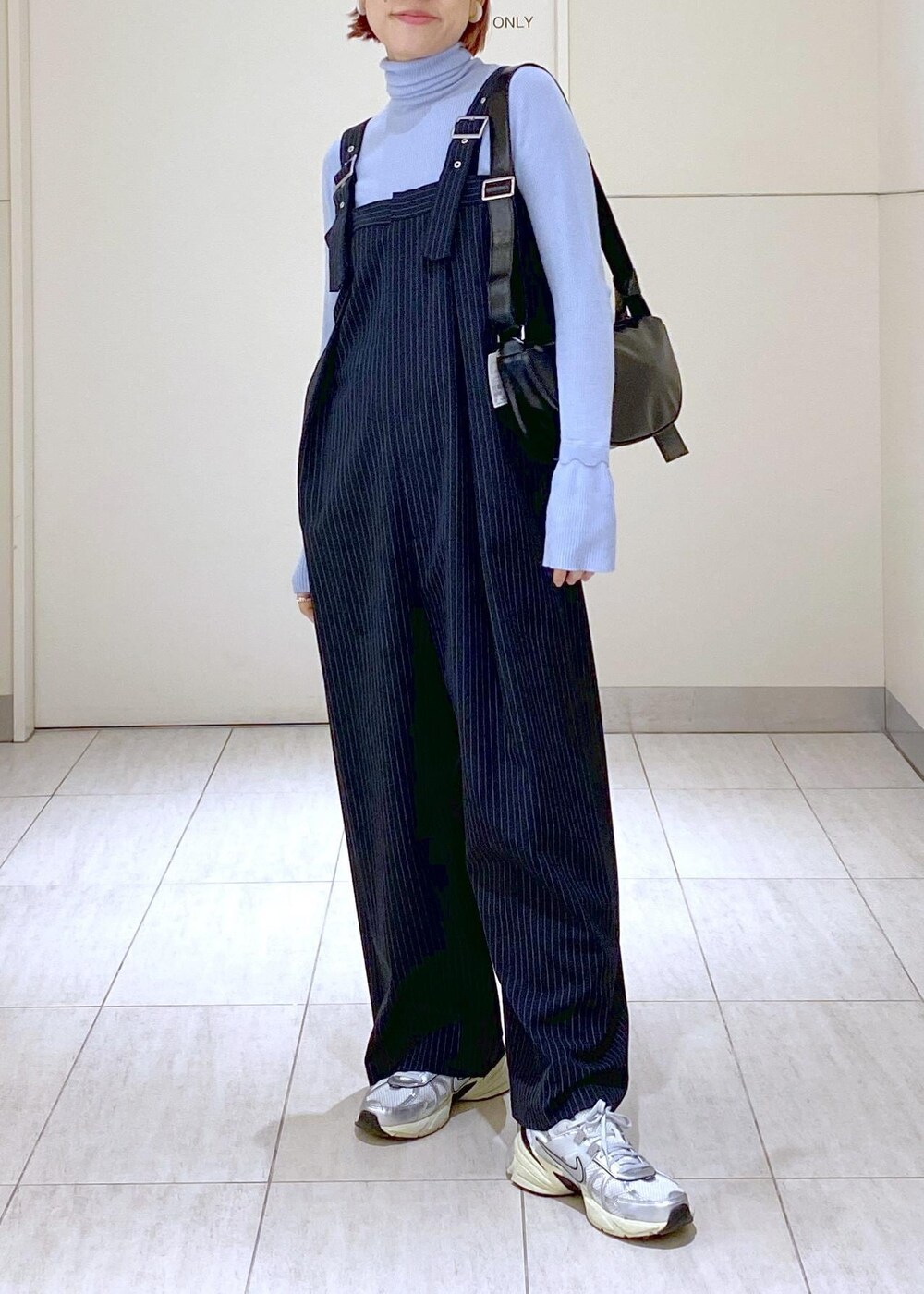 ブルー系のニット/セーター、グレー系のブルゾン、ブラック系のショルダーバッグを着用したレディースの冬コーディネートの5枚目の写真