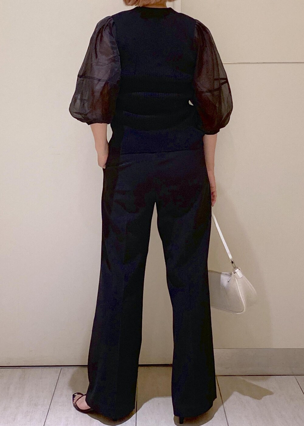 ブラック系のサンダル、ホワイト系のショルダーバッグ、ブラック系のスラックスを着用したレディースの夏コーディネートの3枚目の写真