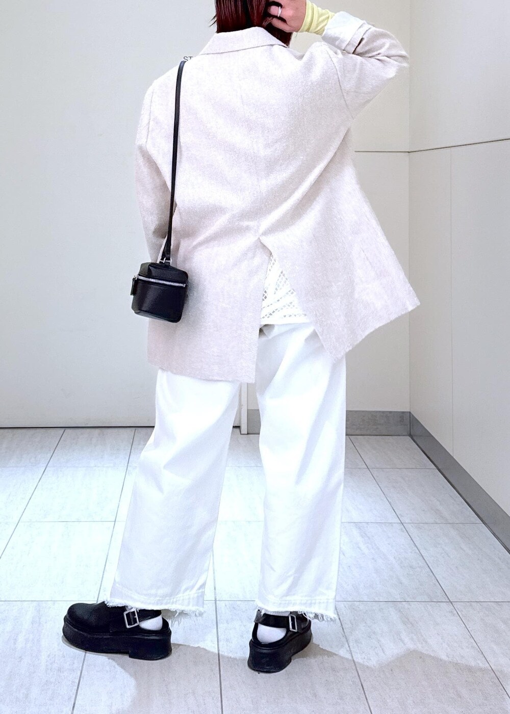 ホワイト系のデニムパンツ、ブラック系のショルダーバッグ、グリーン系のTシャツ/カットソーを着用したレディースの冬コーディネートの6枚目の写真