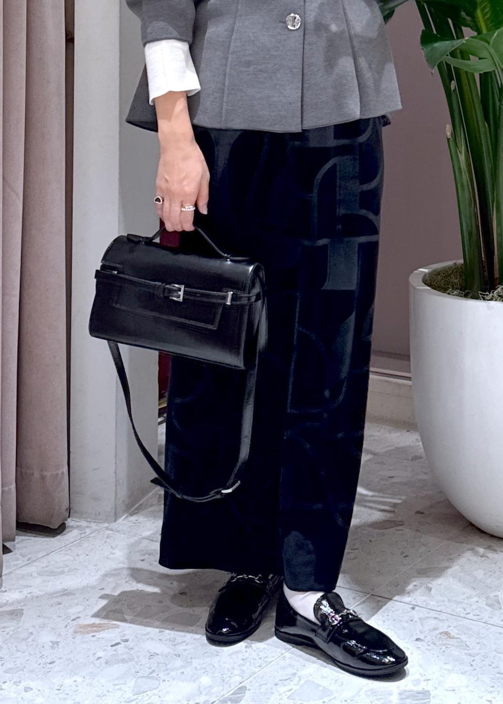 ブラック系のローファー、ブラック系のスカート、グレー系のカーディガン/ボレロを着用したレディースの秋コーディネートの9枚目の写真