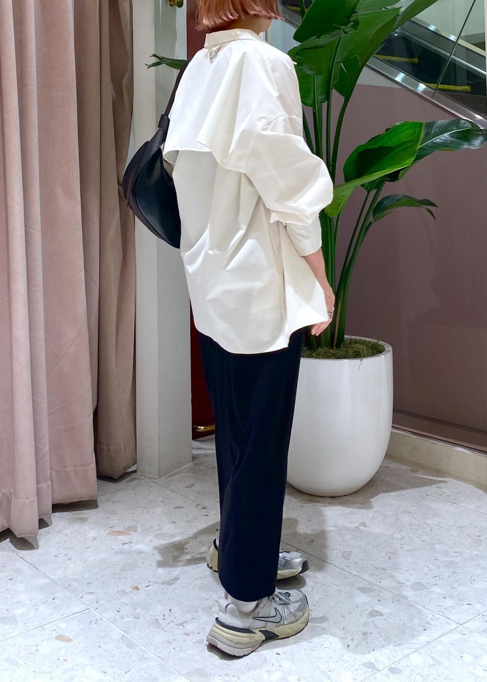 ブラック系のショルダーバッグ、ブラック系のワンピース、ホワイト系のシャツ/ブラウスを着用したレディースの春コーディネートの4枚目の写真