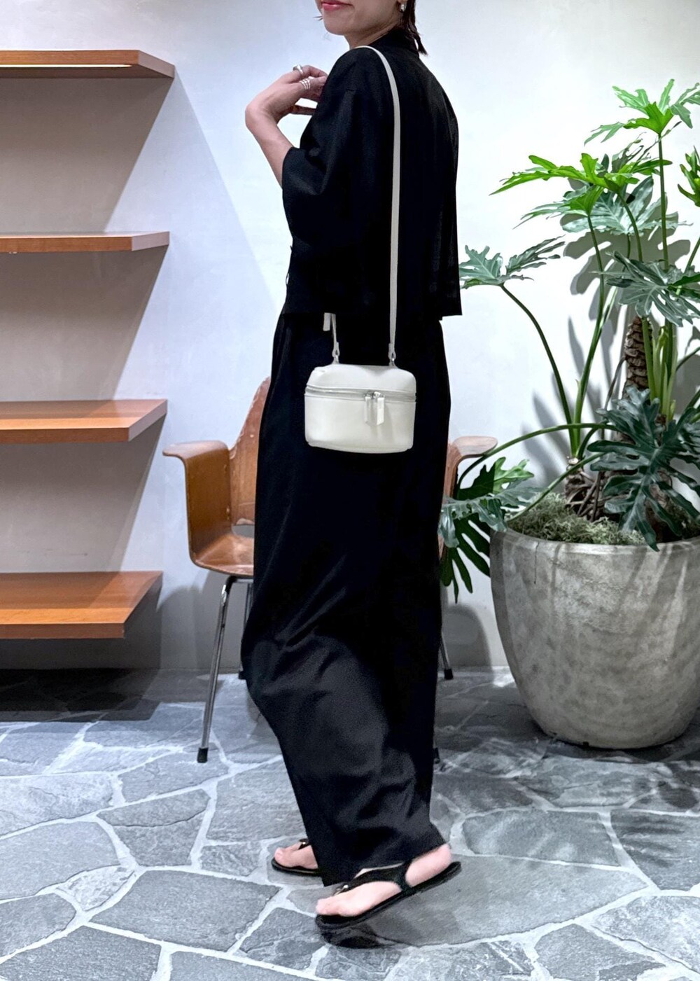 ホワイト系のショルダーバッグ、ブラック系のキャミソール、ブラック系のスラックスを着用したレディースの夏コーディネートの8枚目の写真