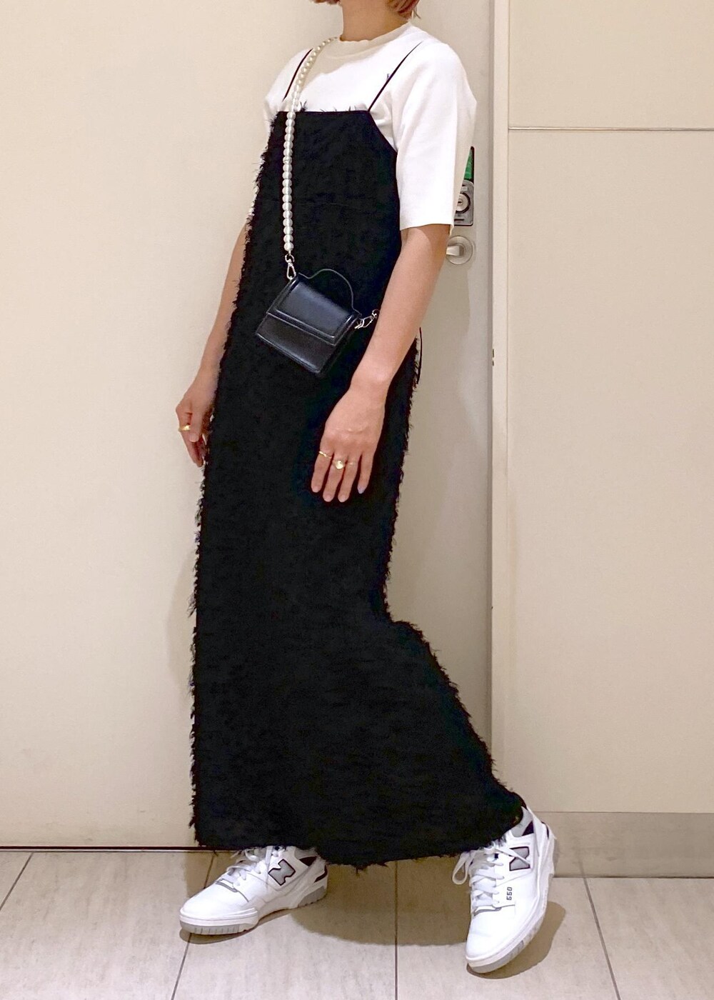 ブラック系のワンピース、グレー系のスニーカー、ブラック系のショルダーバッグを着用したレディースの夏コーディネートの3枚目の写真