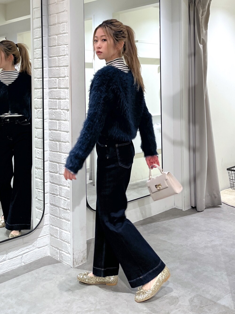 ホワイト系のニット/セーター、ブルー系のカーディガン/ボレロ、ホワイト系のショルダーバッグを着用したレディースの冬コーディネートの3枚目の写真