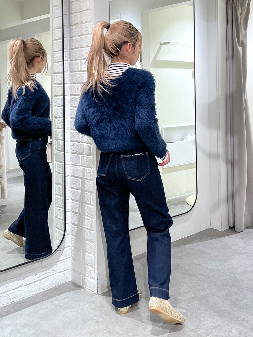 ホワイト系のニット/セーター、ブルー系のカーディガン/ボレロ、ホワイト系のショルダーバッグを着用したレディースの冬コーディネートの5枚目の写真