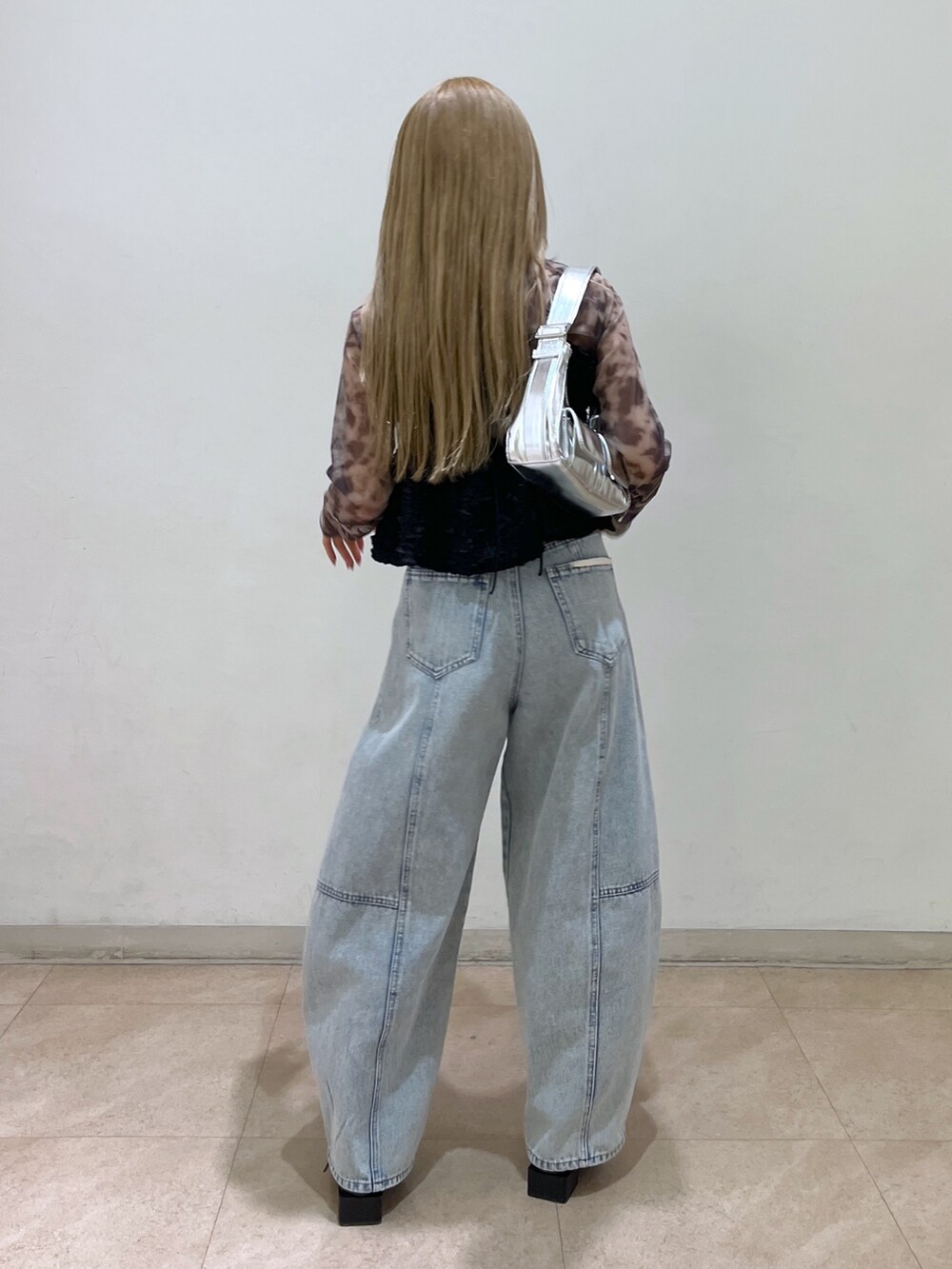 ブラック系のシャツ/ブラウス、シルバー系のショルダーバッグ、ブルー系のデニムパンツを着用したレディースの春コーディネートの5枚目の写真