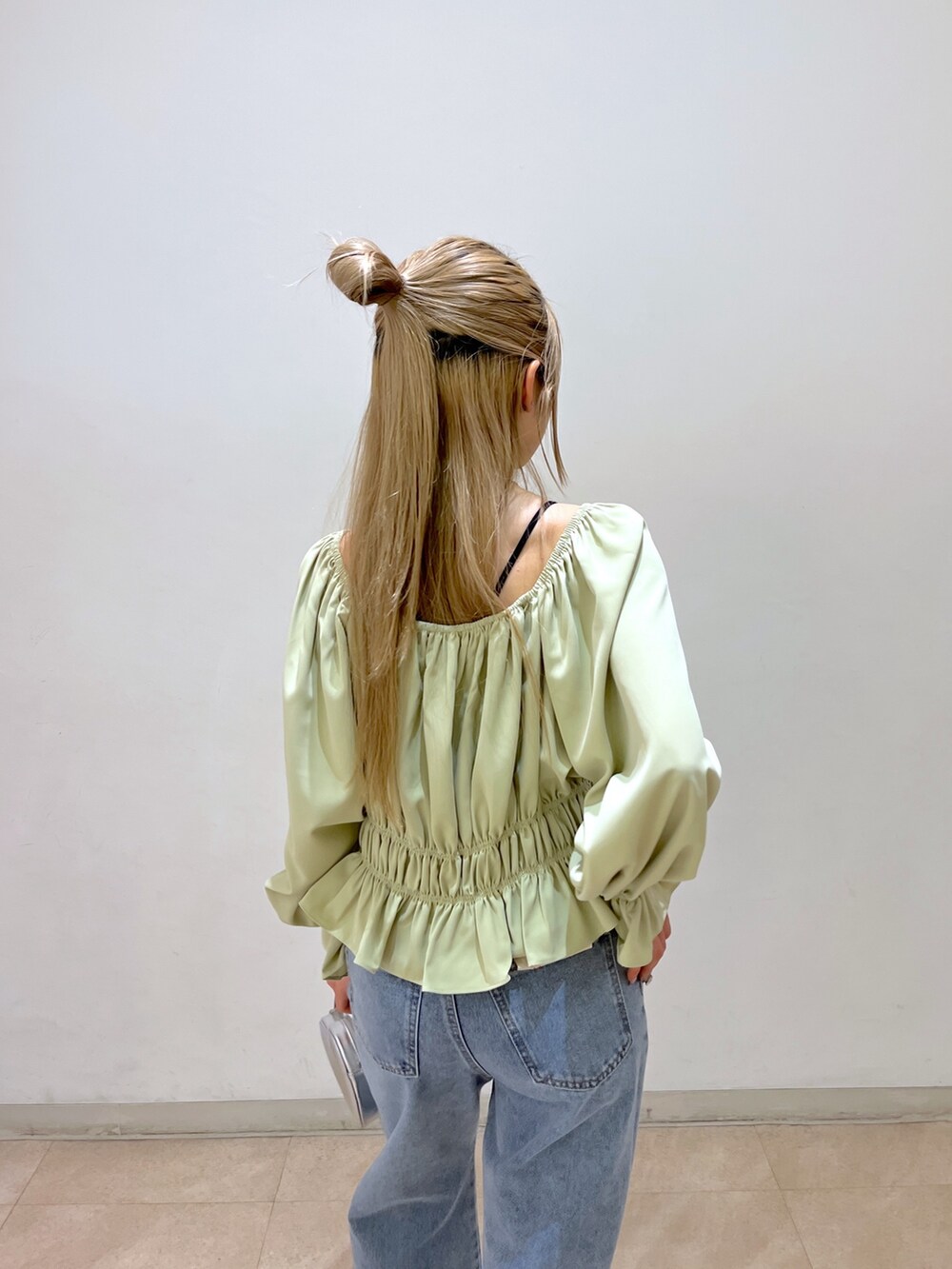 グリーン系のシャツ/ブラウス、シルバー系のショルダーバッグ、ブルー系のデニムパンツを着用したレディースの春コーディネートの7枚目の写真