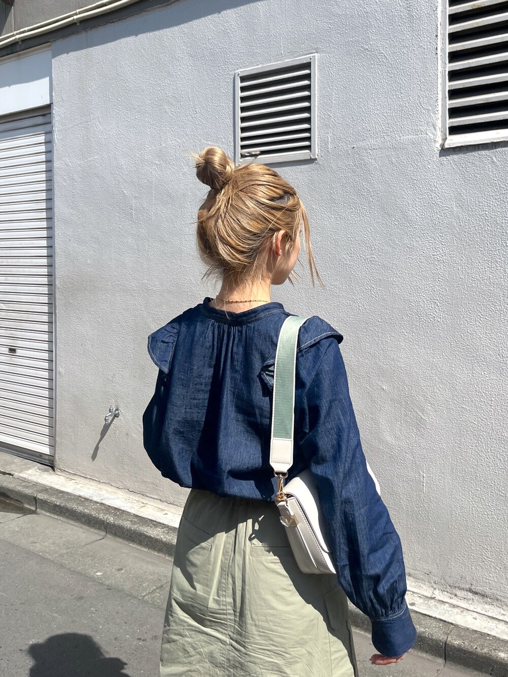 グリーン系のスカート、ホワイト系のショルダーバッグ、ブルー系のシャツ/ブラウスを着用したレディースの春コーディネートの8枚目の写真