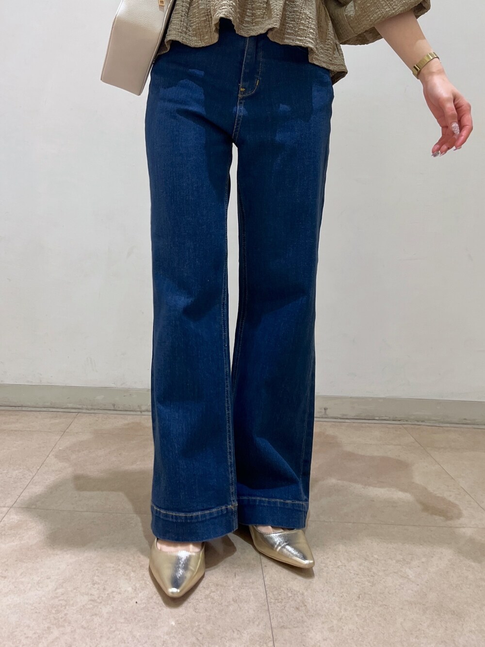 ブラウン系のシャツ/ブラウス、ブルー系のデニムパンツ、ゴールド系のパンプスを着用したレディースの春コーディネートの8枚目の写真