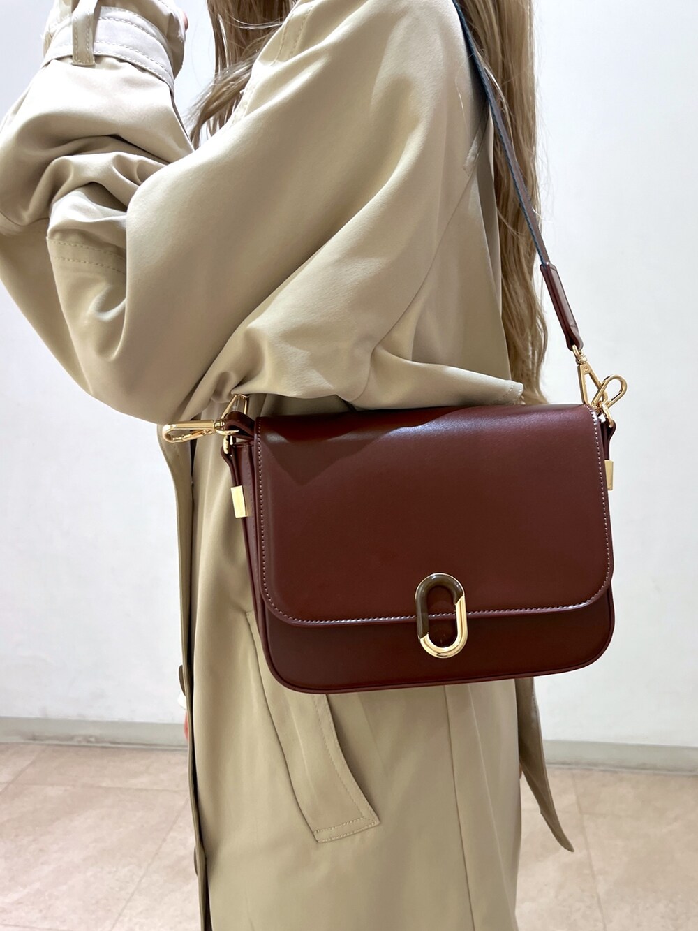 ホワイト系のシャツ/ブラウス、ベージュ系のトレンチコート、ブラウン系のショルダーバッグを着用したレディースの春コーディネートの9枚目の写真