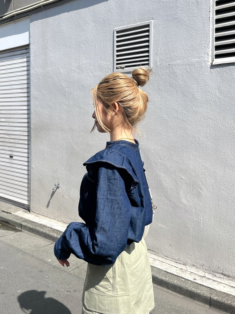 グリーン系のスカート、ホワイト系のショルダーバッグ、ブルー系のシャツ/ブラウスを着用したレディースの春コーディネートの7枚目の写真