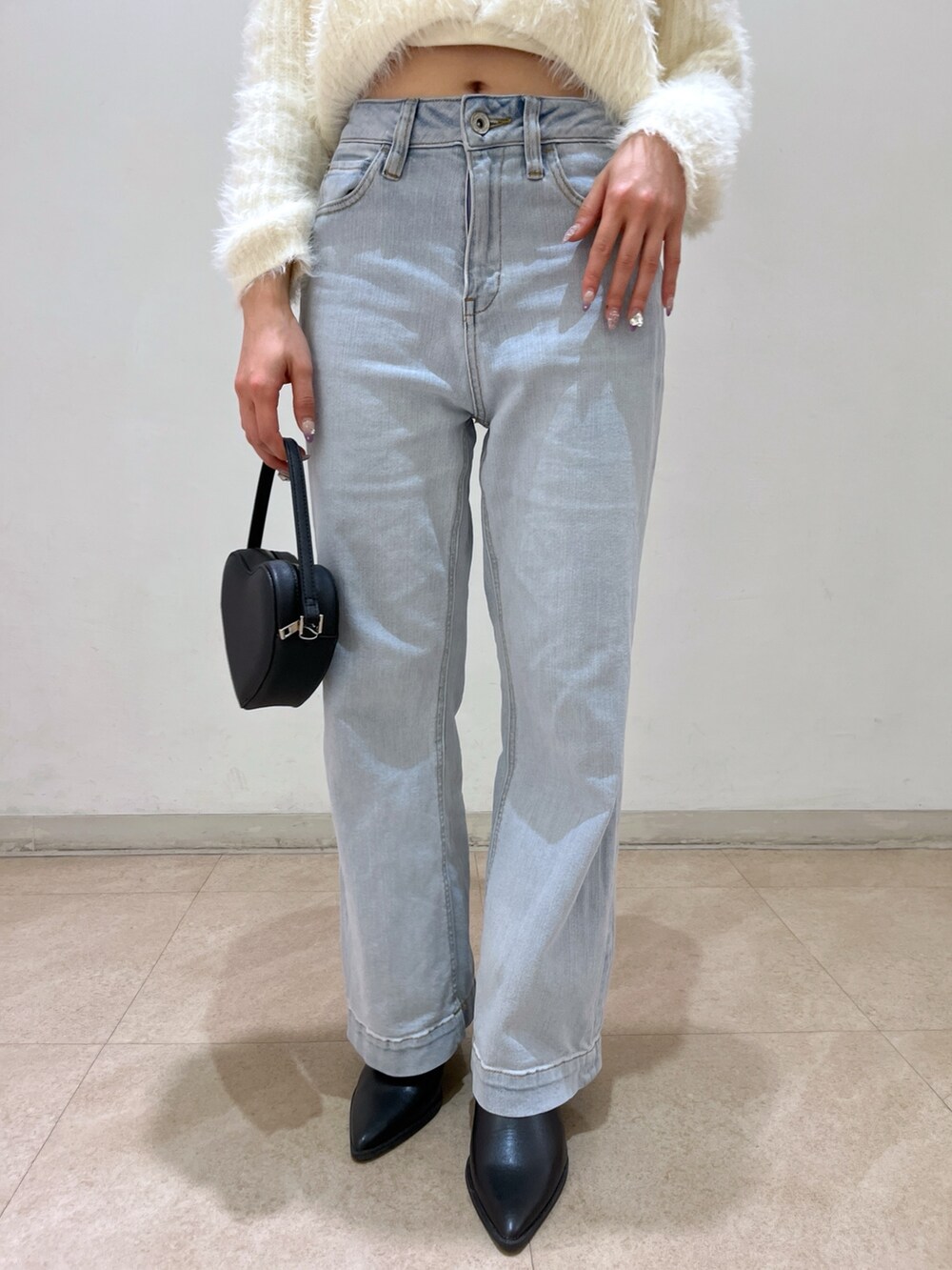 ホワイト系のカーディガン/ボレロ、ブルー系のデニムパンツ、ブラック系のショルダーバッグを着用したレディースの春コーディネートの8枚目の写真