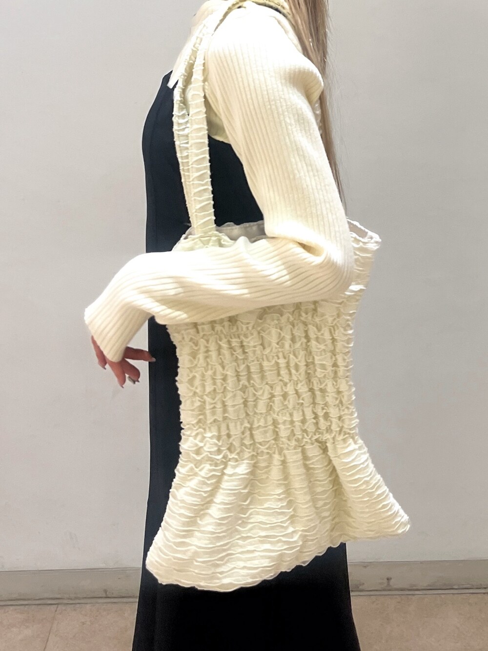 ホワイト系のニット/セーター、ブラック系のワンピース、ホワイト系のトートバッグを着用したレディースの春コーディネートの9枚目の写真