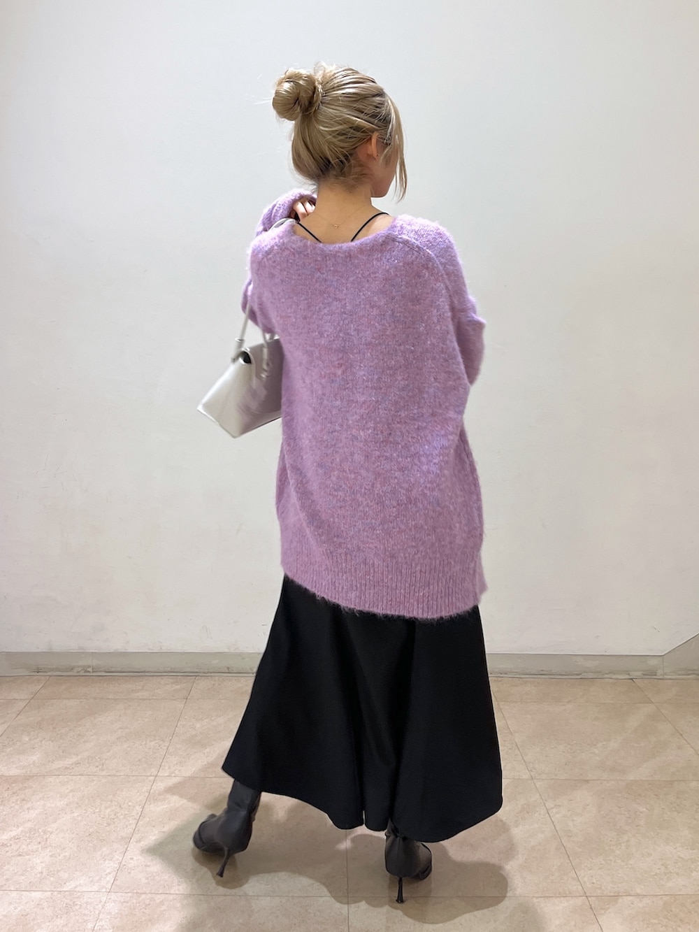 ブラック系のワンピース、パープル系のカーディガン/ボレロ、ホワイト系のショルダーバッグを着用したレディースの冬コーディネートの5枚目の写真