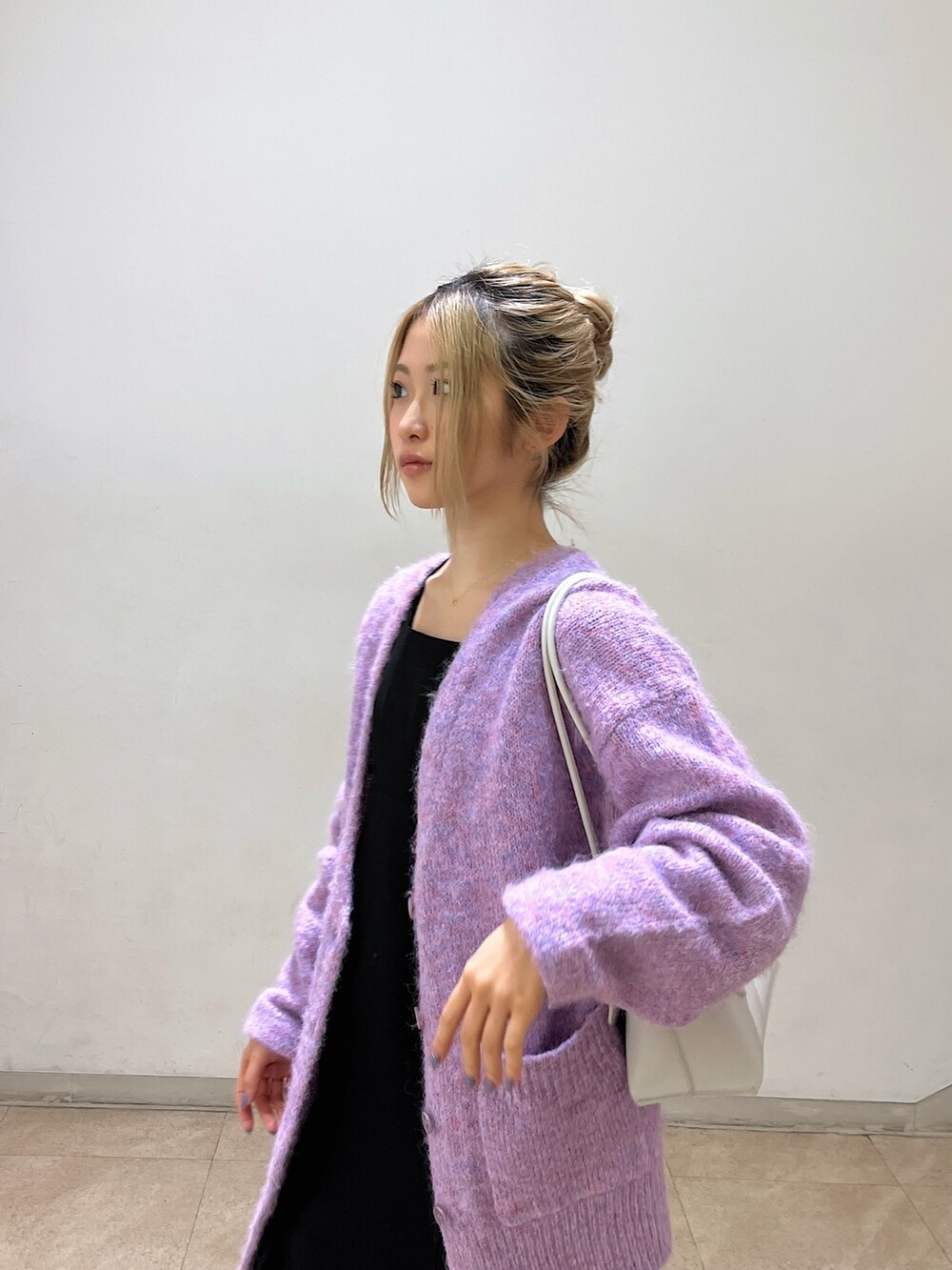 ブラック系のワンピース、パープル系のカーディガン/ボレロ、ホワイト系のショルダーバッグを着用したレディースの冬コーディネートの7枚目の写真