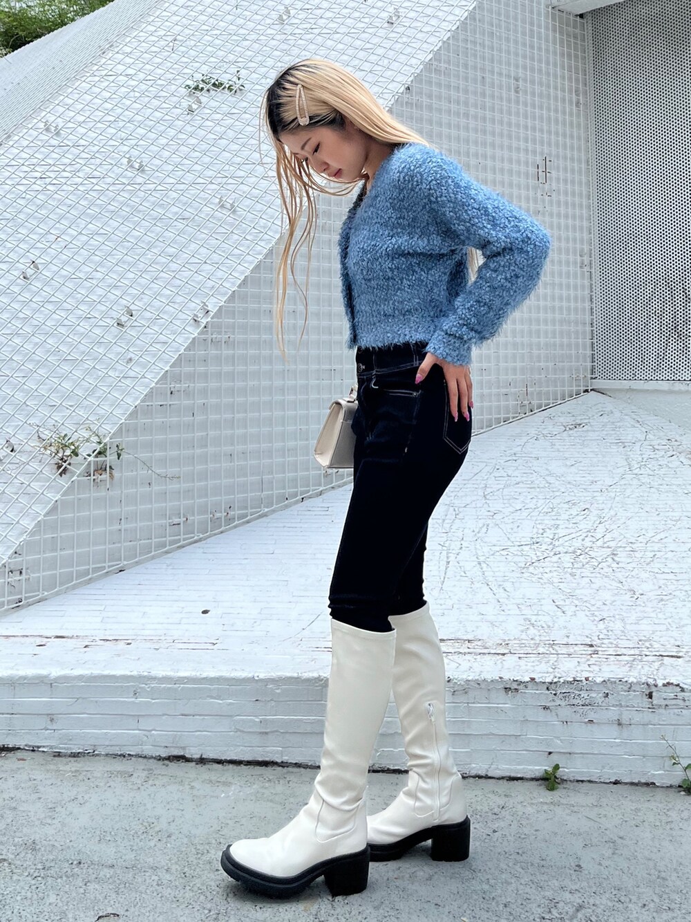 ブルー系のカーディガン/ボレロ、ホワイト系のブーツ、ホワイト系のショルダーバッグを着用したレディースの秋コーディネートの2枚目の写真