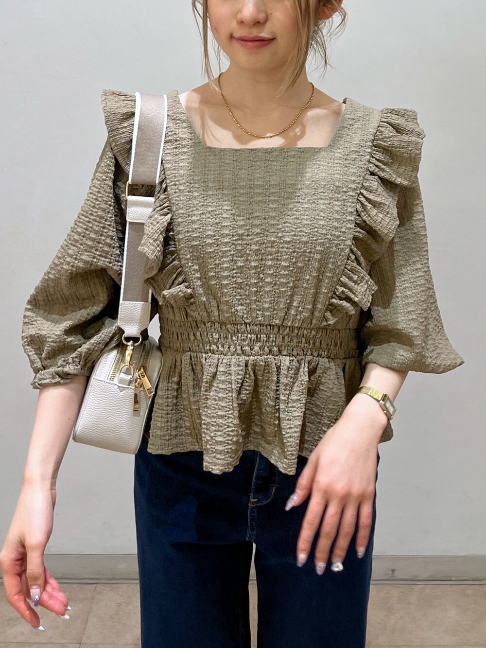 ブラウン系のシャツ/ブラウス、ブルー系のデニムパンツ、ゴールド系のパンプスを着用したレディースの春コーディネートの5枚目の写真