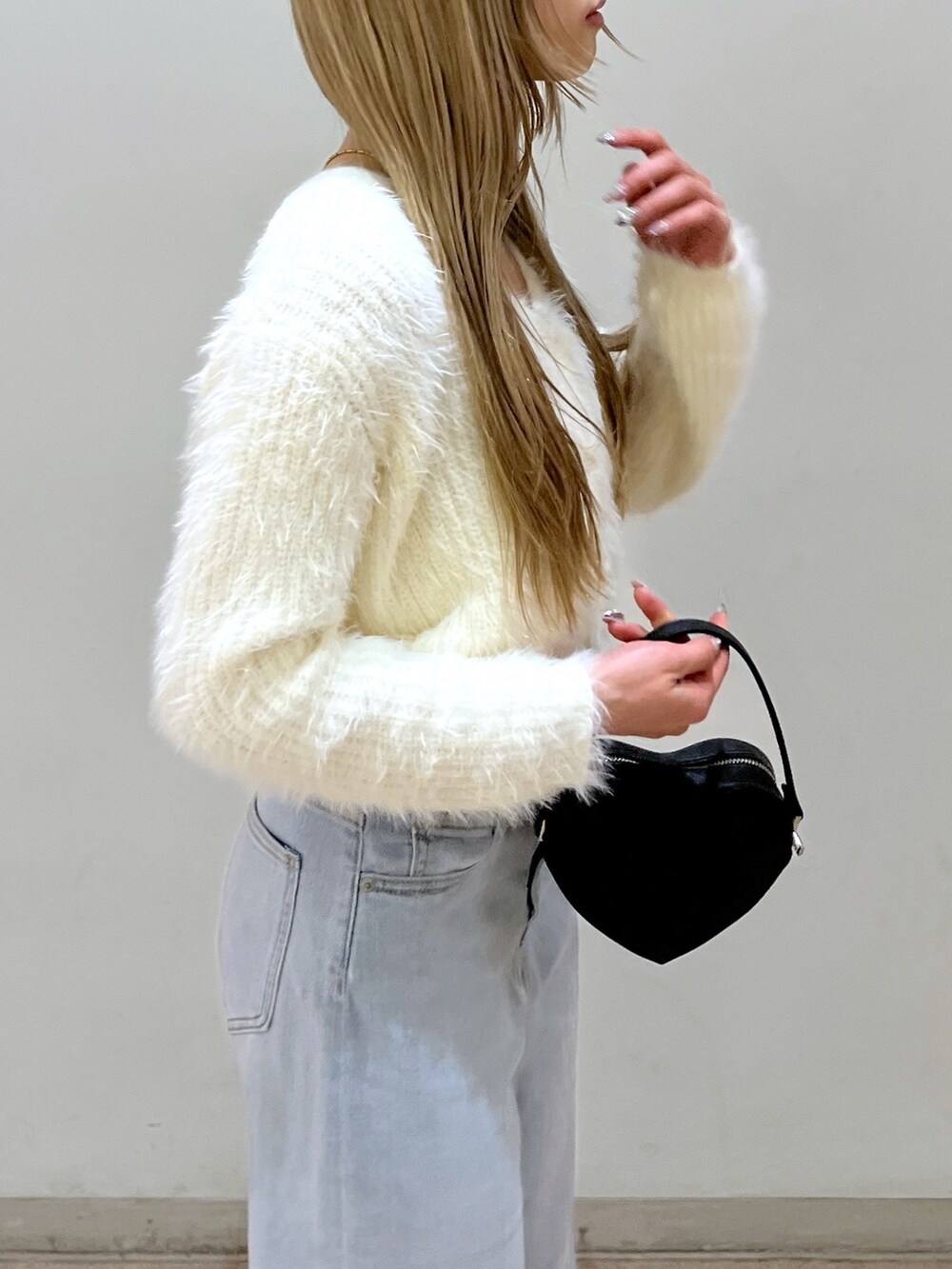 ホワイト系のカーディガン/ボレロ、ブルー系のデニムパンツ、ブラック系のショルダーバッグを着用したレディースの春コーディネートの5枚目の写真