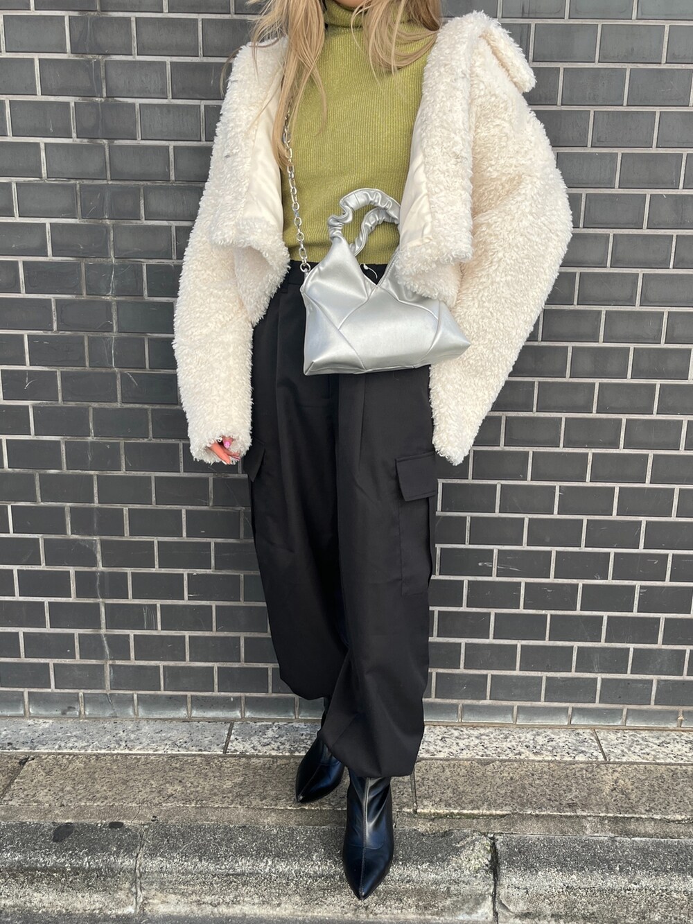 ホワイト系のブルゾン、ブラック系のカーゴパンツ、ブラック系のブーツを着用したレディースの秋コーディネートの8枚目の写真