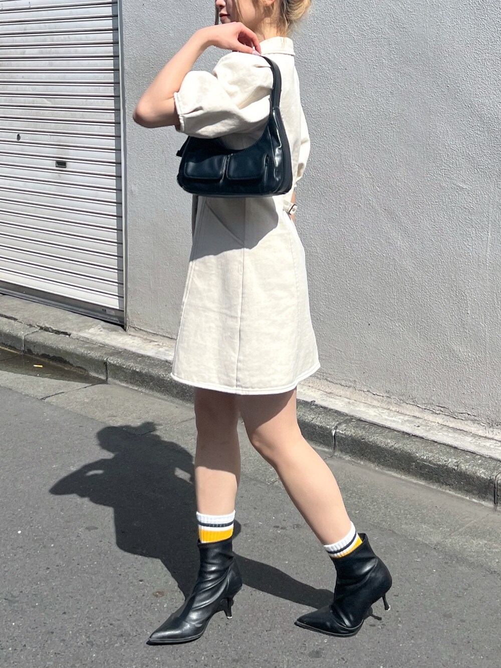 ブラック系のショルダーバッグ、ホワイト系のワンピースを着用したレディースの春コーディネートの4枚目の写真