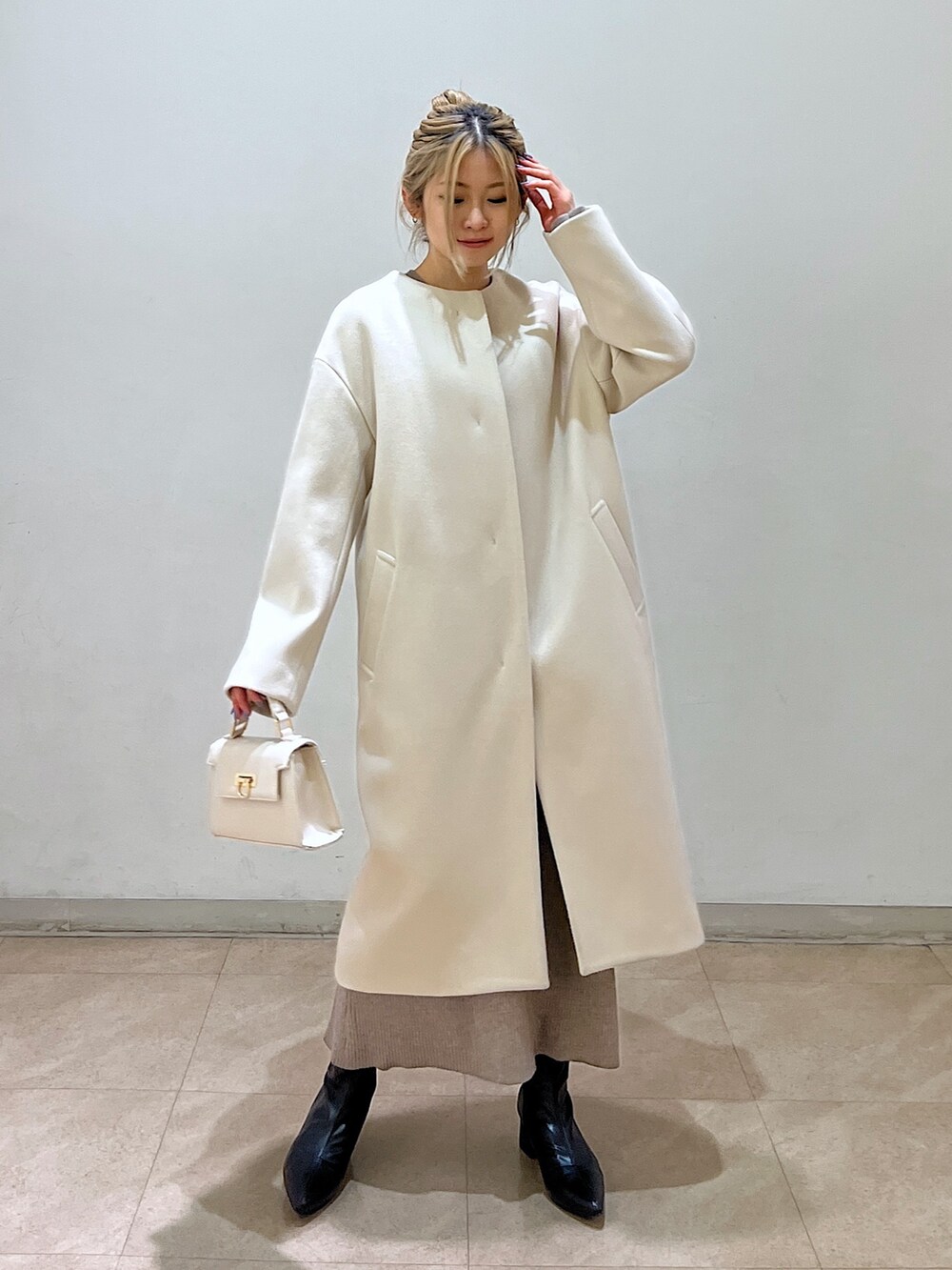 ベージュ系のノーカラーコート、ホワイト系のシャツ/ブラウス、ベージュ系のワンピースを着用したレディースの冬コーディネートの8枚目の写真