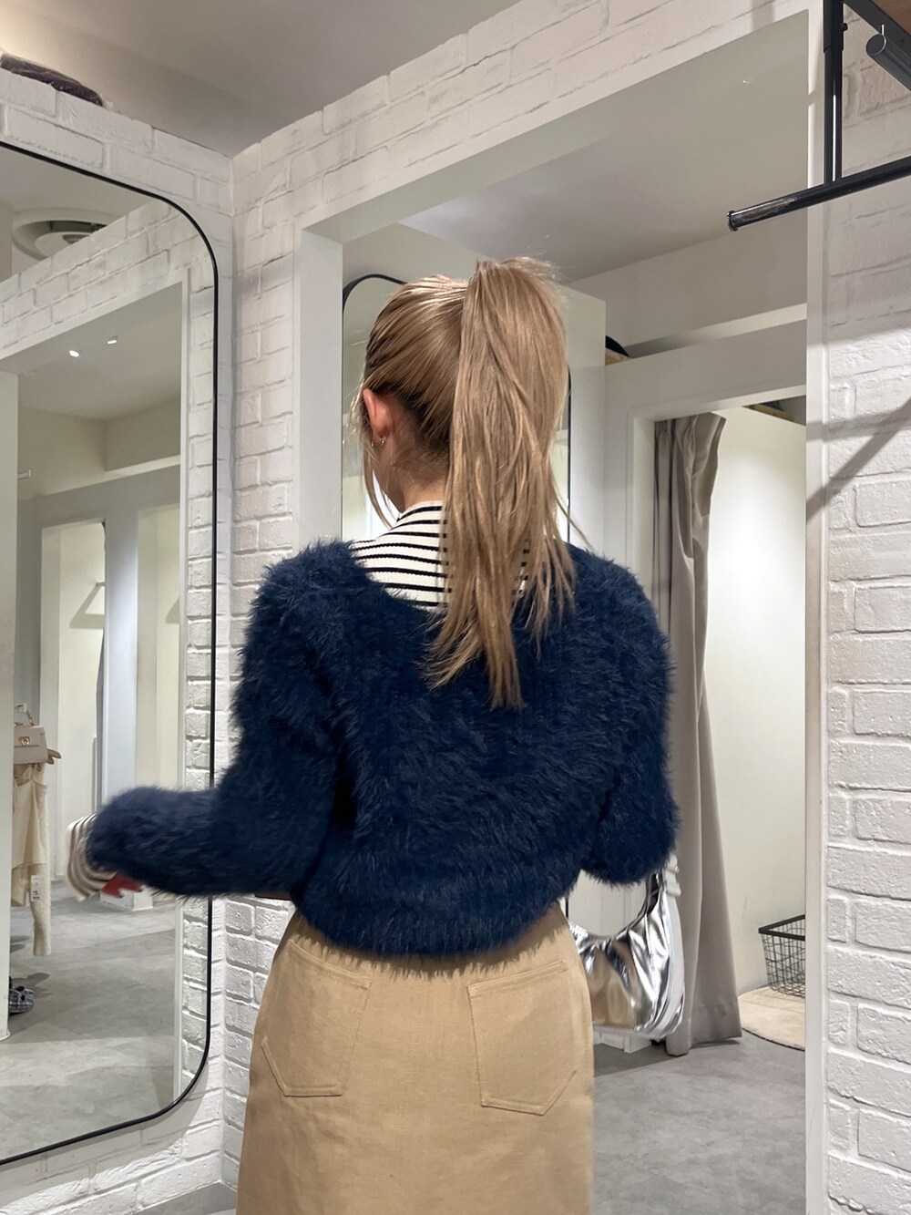 ブルー系のカーディガン/ボレロ、ホワイト系のニット/セーター、ブラック系のブーツを着用したレディースの冬コーディネートの8枚目の写真