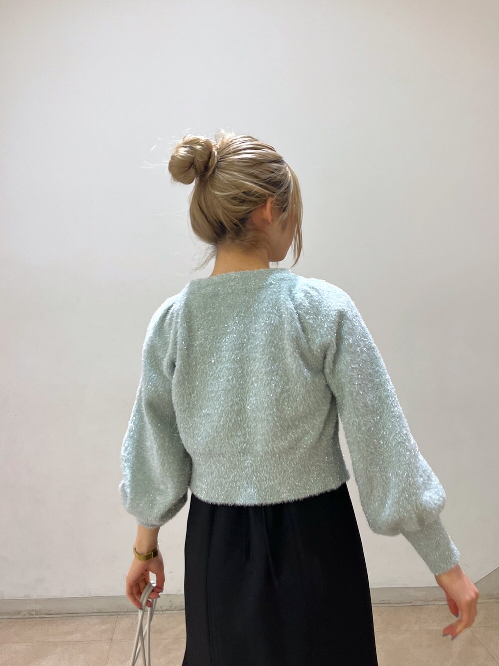 グリーン系のカーディガン/ボレロ、ホワイト系のショルダーバッグ、ブラック系のワンピースを着用したレディースの冬コーディネートの9枚目の写真