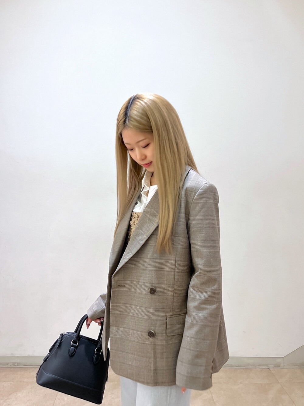 ブラック系のショルダーバッグ、ブルー系のデニムパンツ、ブラック系のパンプスを着用したレディースの春コーディネートの7枚目の写真