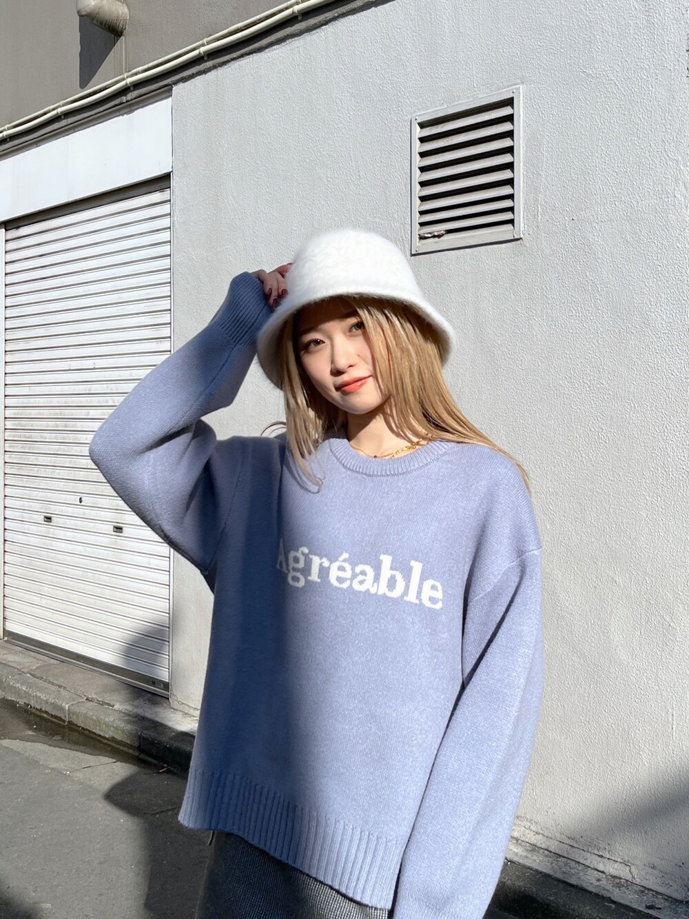 ホワイト系のスカート、ブルー系のニット/セーター、ブラック系のスカートを着用したレディースの冬コーディネートの4枚目の写真