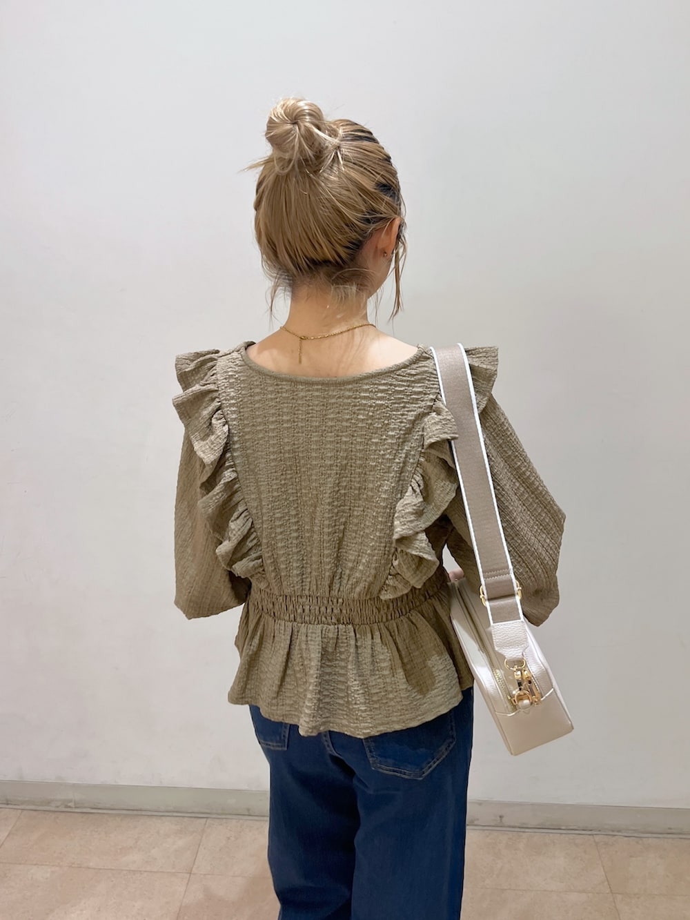 ブラウン系のシャツ/ブラウス、ブルー系のデニムパンツ、ゴールド系のパンプスを着用したレディースの春コーディネートの7枚目の写真