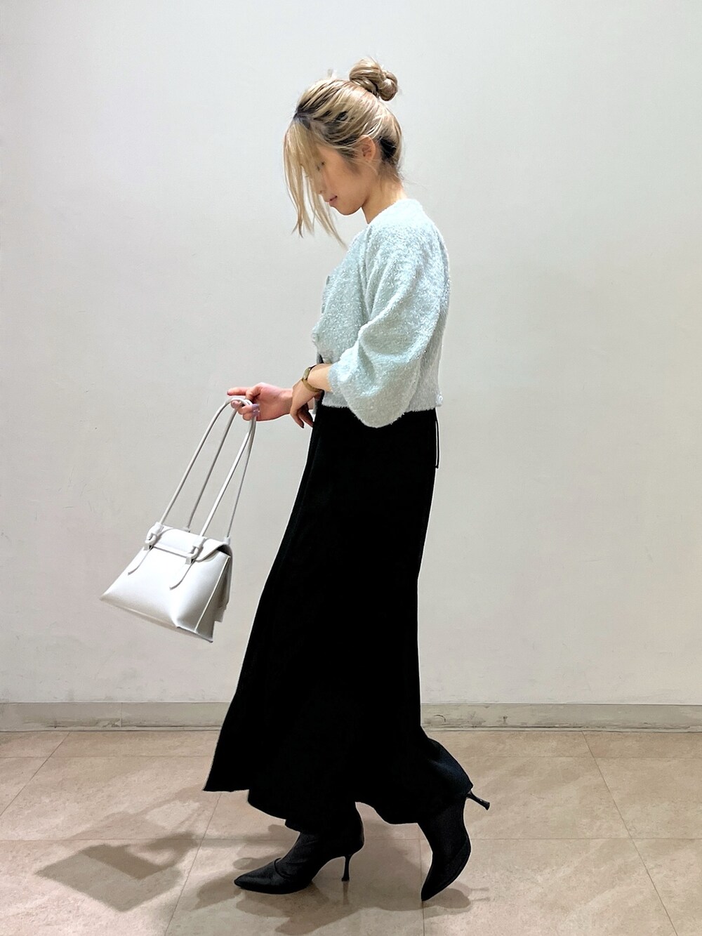 グリーン系のカーディガン/ボレロ、ホワイト系のショルダーバッグ、ブラック系のワンピースを着用したレディースの冬コーディネートの6枚目の写真