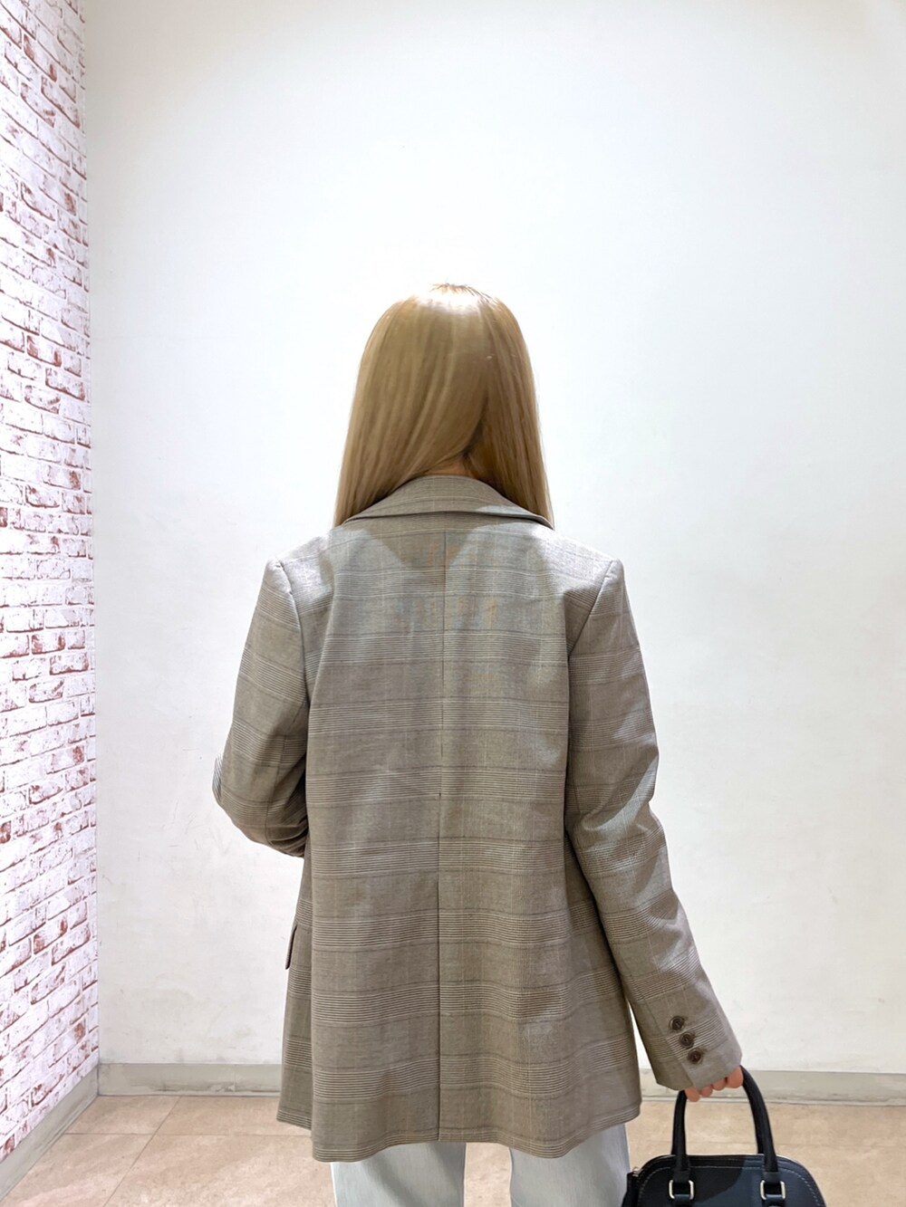 ブラック系のショルダーバッグ、ブルー系のデニムパンツ、ブラック系のパンプスを着用したレディースの春コーディネートの9枚目の写真