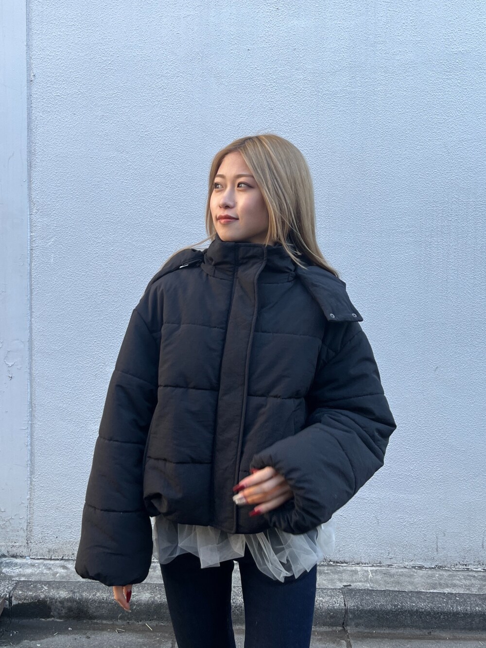 ホワイト系のシャツ/ブラウス、グレー系のニット/セーター、ブルー系のデニムパンツを着用したレディースの冬コーディネートの7枚目の写真