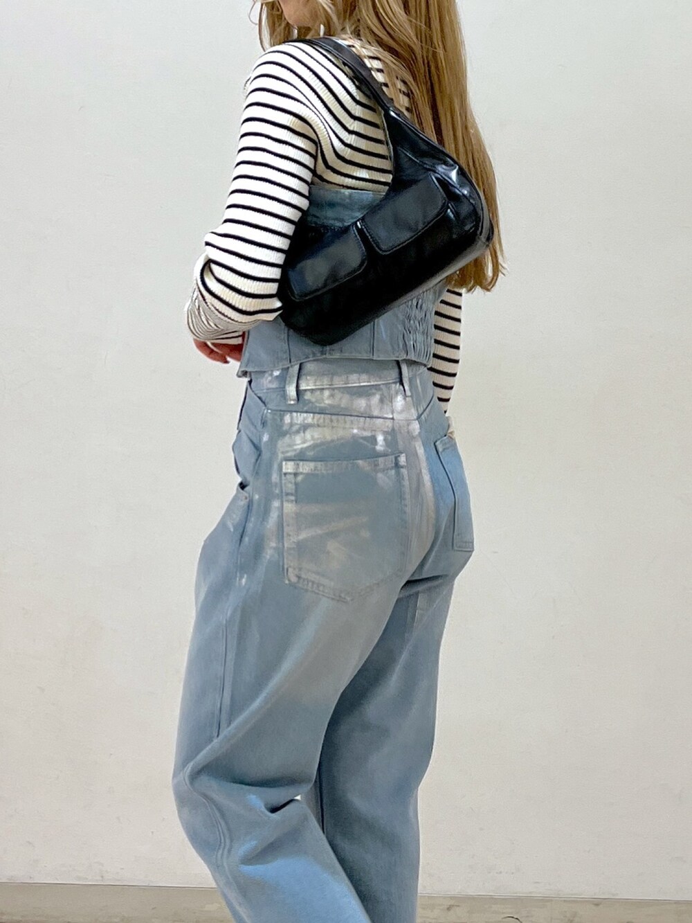 ブルー系のベスト、ホワイト系のニット/セーター、ブラック系のショルダーバッグを着用したレディースの冬コーディネートの9枚目の写真