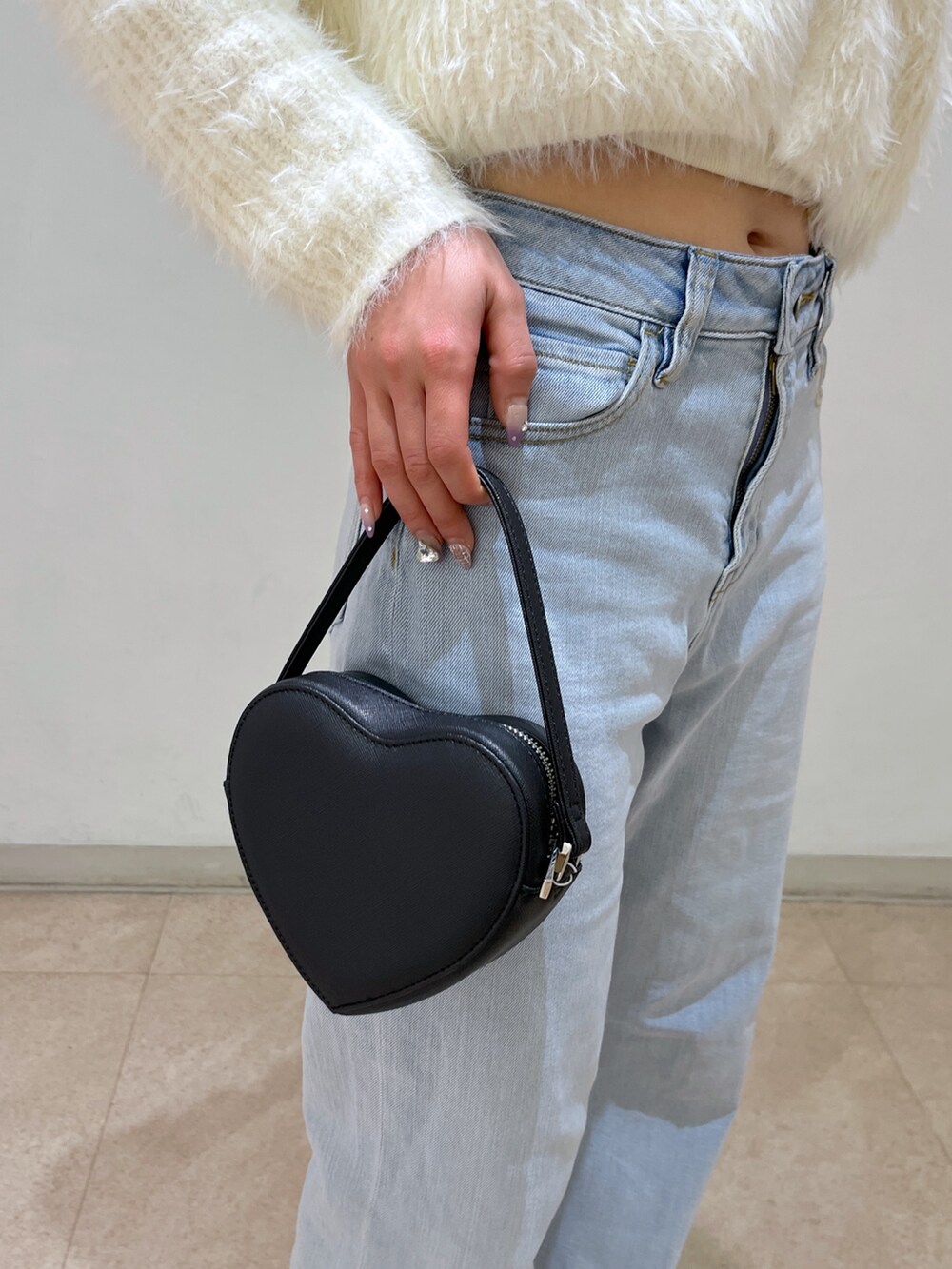 ホワイト系のカーディガン/ボレロ、ブルー系のデニムパンツ、ブラック系のショルダーバッグを着用したレディースの春コーディネートの10枚目の写真