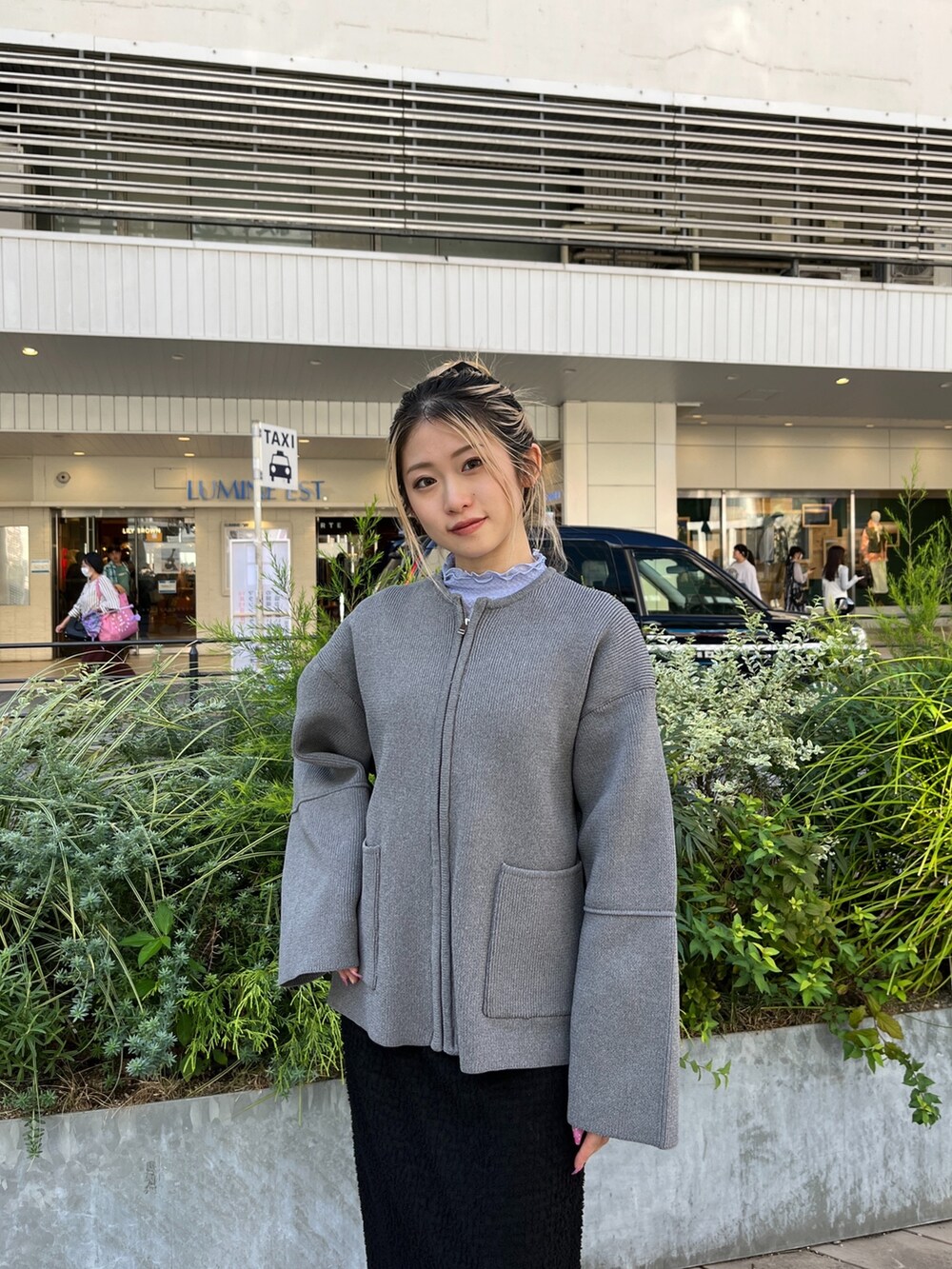 グレー系のカーディガン/ボレロ、ブラック系のスカート、ホワイト系のスニーカーを着用したレディースの秋コーディネートの5枚目の写真