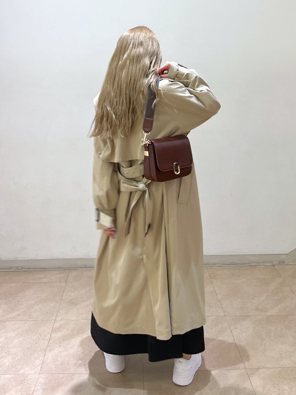 ホワイト系のシャツ/ブラウス、ベージュ系のトレンチコート、ブラウン系のショルダーバッグを着用したレディースの春コーディネートの4枚目の写真