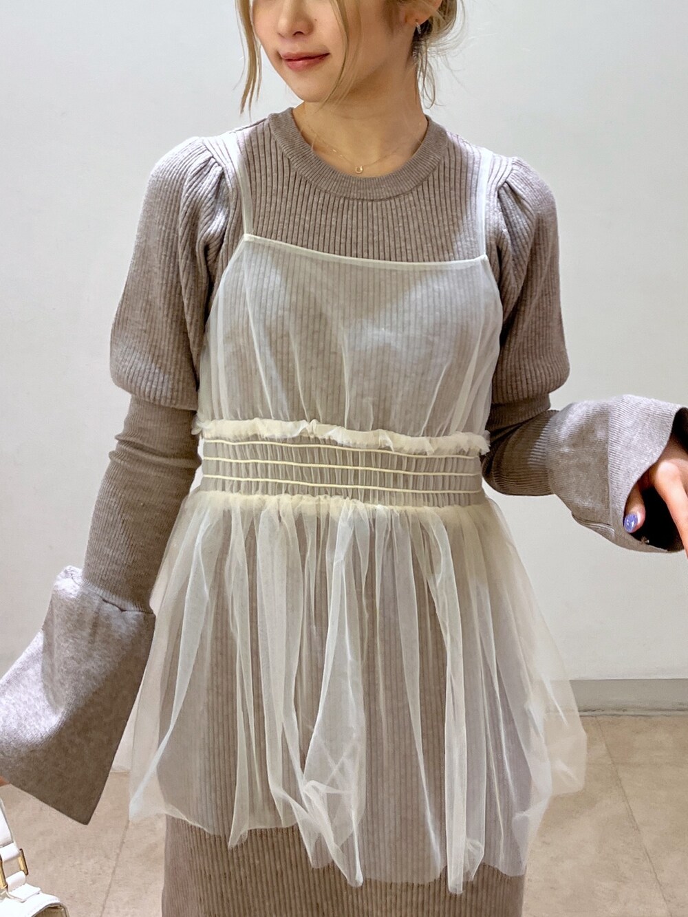 ホワイト系のショルダーバッグ、ブラック系のブーツ、ベージュ系のワンピースを着用したレディースの冬コーディネートの9枚目の写真